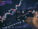 Trader investor broker holding finger using cell phone app executing financial stock trade market trading order to buy or sell