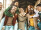 Happy multiracial best friends having fun hanging on city street