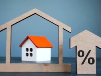 House model, arrow and percent sign as mortgage rates concept.